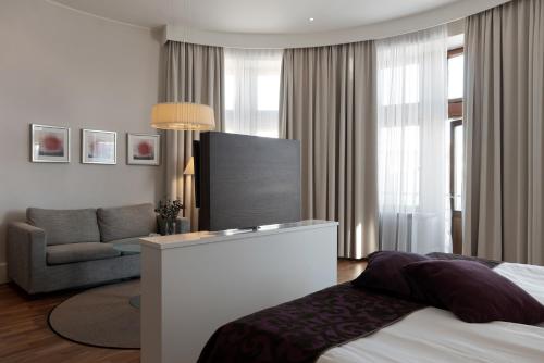 a hotel room with a bed and a couch at Elite Stadshotellet Luleå in Luleå