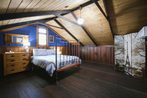 1 dormitorio con cama y techo de madera en The Dairy - 2 Story Rustic style accommodation with Mod Cons, en Hoddy Well