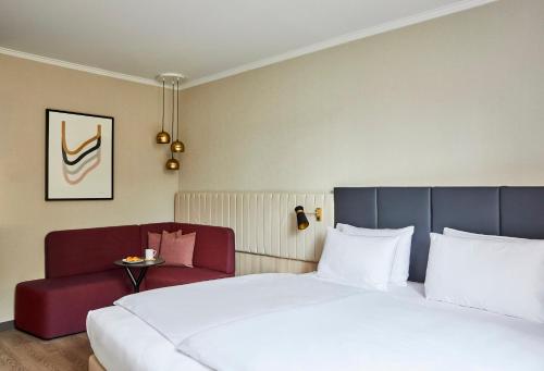 a hotel room with a bed and a couch at Crowne Plaza Hamburg-City Alster by IHG in Hamburg