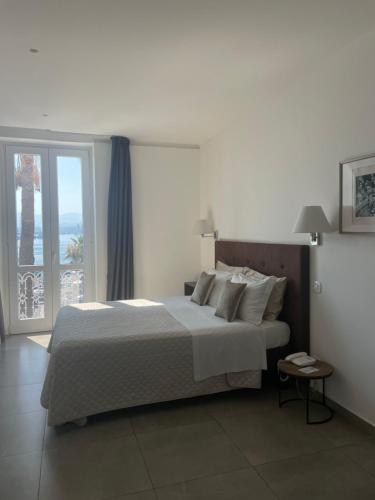 a bedroom with a large bed and a large window at Liberty Palace in Milazzo