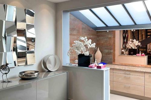 a living room with a skylight and a mirror at Charming townhouse with garden in the City of Love in Paris