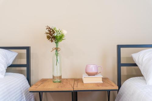 a vase of flowers on a table between two beds at Hotel Latveli Mestia in Mestia