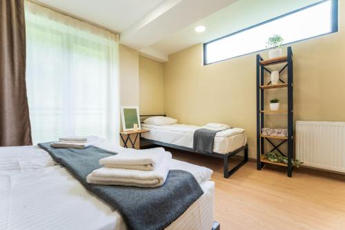 Hotel Latveli Mestia في ميستيا: غرفة نوم بسريرين عليها مناشف
