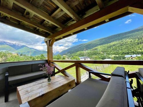 a porch with a couch and a wooden table at Hotel Latveli Mestia in Mestia