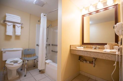 a bathroom with a toilet and a sink and a mirror at Best Western of Lake George in Lake George