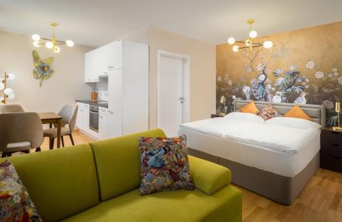 a bedroom with a bed and a green couch at Abieshomes Serviced Apartments Schönbrunn in Vienna