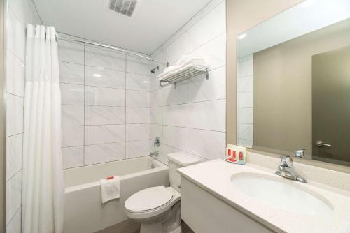 a bathroom with a sink and a toilet and a tub at Econo Lodge in Prince George