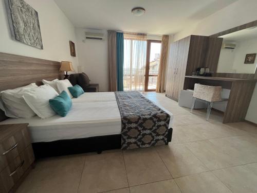 a bedroom with a large bed with blue pillows at Time out in Sozopol