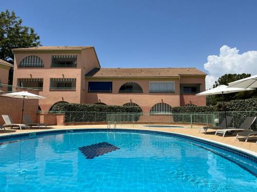 une grande piscine devant un immeuble dans l'établissement Les jardins de la mer, à Linguizzetta