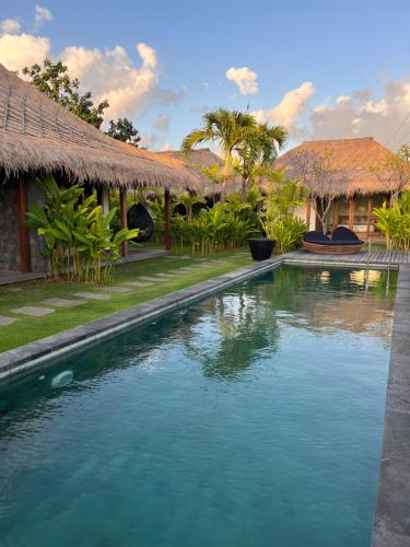 a swimming pool in front of a house at La Reserva Villas Bali in Jimbaran