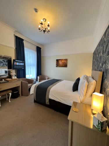 a hotel room with a bed and a desk at Birkdale Guest House in Shanklin
