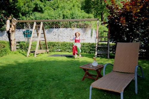 a little girl standing on a swing in a yard at Sportpension Bergblick in Wagrain
