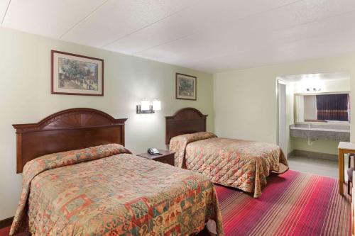 a hotel room with two beds and a window at Rodeway Inn in South Point