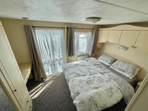 Habitación pequeña con cama y ventana en 2 Bedroom Park home in Uddingston, Glasgow, en Uddingston