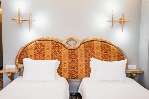 two beds in a room with crosses on the wall at SunGarden Golf & Spa Resort in Cluj-Napoca