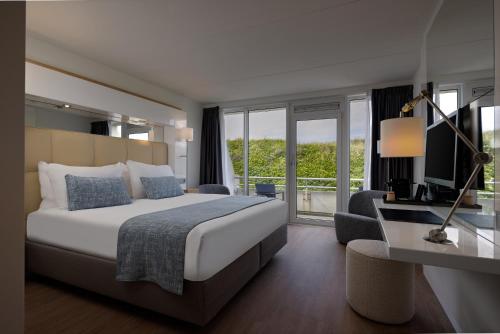 a bedroom with a large bed and a large window at WestCord Strandhotel Seeduyn in Oost-Vlieland