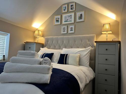 una camera da letto con un grande letto con lenzuola e cuscini bianchi di The Tower, 1 bed 1850's Tiny House a Maldon