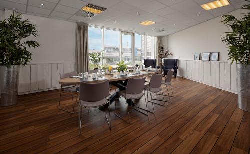 a conference room with a long table and chairs at WestCord Strandhotel Seeduyn in Oost-Vlieland
