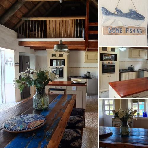 a kitchen with a wooden table with a vase of flowers at Casa Pescador Beach House in Struisbaai