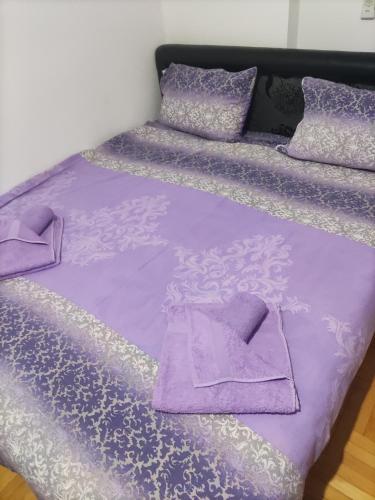 a purple bed with purple sheets and pillows at Apartments Milijana in Soko Banja