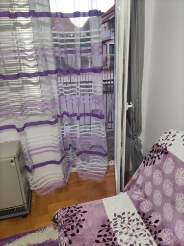 a room with a window with purple and white pillows at Apartments Milijana in Soko Banja