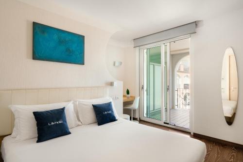 um quarto com uma grande cama branca com almofadas azuis em Life Hotel Seaview & Spa em Porto Recanati