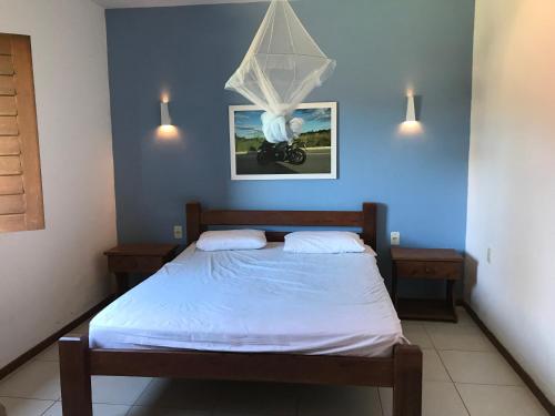 a bedroom with a bed with a blue wall at Sitio Maravilha in Mulungu