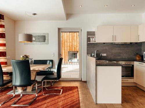 een keuken en eetkamer met een tafel en stoelen bij Patteriol Lodge in Sankt Anton am Arlberg