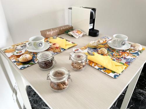 un tavolo con tazze e piatti di cibo sopra di Centopassi Noto B&B a Noto