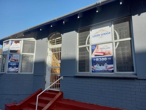 a store with signs in the windows of a building at Linze lodge in Durban