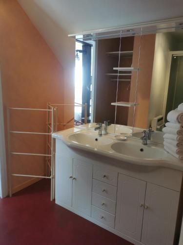 une salle de bain avec un lavabo et un miroir dans l'établissement Le Balcon des Vents, à Granville