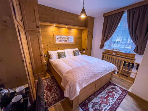 a bedroom with a large bed and a window at Hotel da Beppe Sello in Cortina dʼAmpezzo