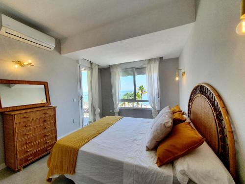 a bedroom with a bed and a dresser and a window at Estepona Vistamar 3 bedrooms in Estepona