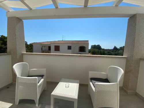 a patio with chairs and a table on a balcony at Villa Lentischio in Budoni