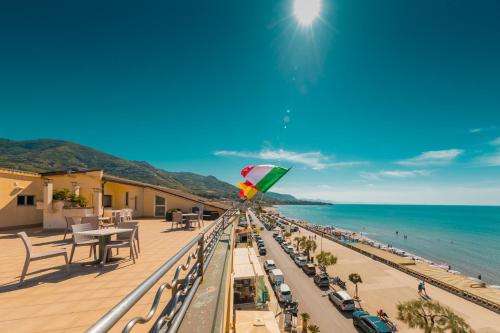 a kite is flying on a balcony overlooking the beach at Hotel Riva Del Sole in Cefalù