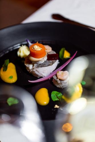 a plate of food with an egg and other foods at Mallaun Hotel.Erlebnis in See