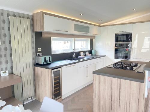 a kitchen with white cabinets and a counter top at Spring Lodge in South Cerney