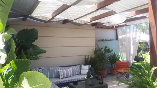 a patio with a couch and some plants at Modern Villa in Chania in Perivólia