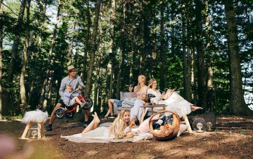 a group of people sitting around in the woods at Pohorje Village Wellbeing Resort - Forest Hotel Videc in Pohorje