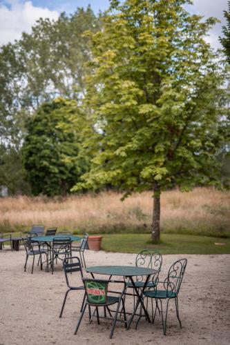een groep tafels en stoelen in een park bij La Planque en Perche in Bellou-le-Trichard