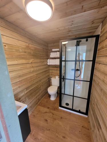 a bathroom with a toilet and a glass shower at Parkhoeve Glamping in Ham