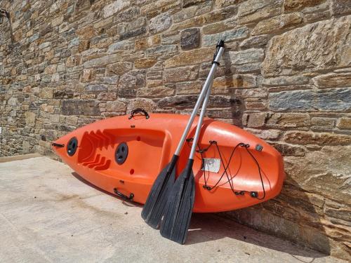 an orange kayak sitting next to a brick wall at Seastone Villas in Almiropótamos
