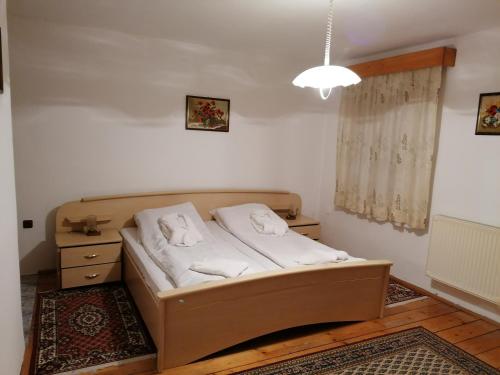 a small bedroom with a bed and a night stand at Pensiunea Spack in Cristian