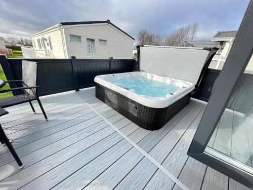 a hot tub sitting on top of a deck at Spring Lodge in South Cerney