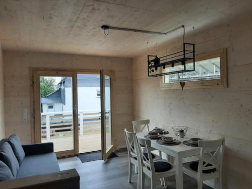 a dining room with a white table and chairs at Hunsrück Chalet 