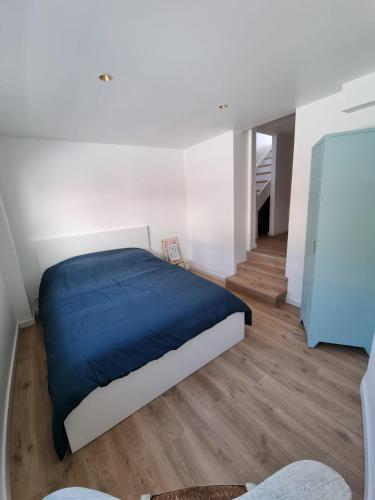 une chambre avec un lit avec une couverture bleue dans l'établissement Stella Cab'in, à Cucq