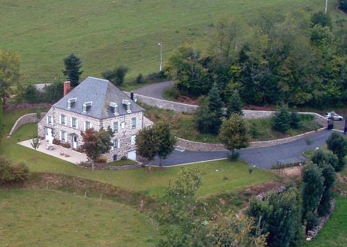 an aerial view of a large house with a road at Maison d'Hôtes La Nichée in Rochefort-Montagne