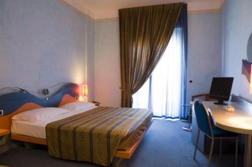 una camera d'albergo con letto e scrivania con computer di Hotel Del Sole a Margherita di Savoia