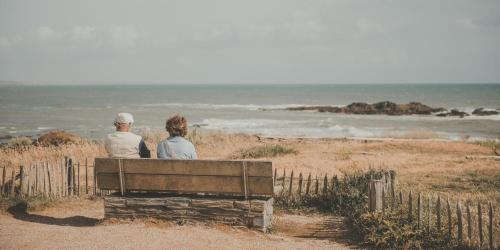 two people sitting on a bench looking at the ocean at ibis Styles St Gilles Croix de Vie centre-ville in Saint-Gilles-Croix-de-Vie