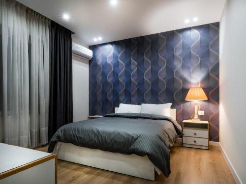 a bedroom with a bed and a blue wall at Prestige Hotel Suites - برستيج للشقق الفندقية in Amman